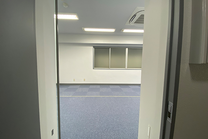 濃いネイビーと間接照明で仕上げたオフィスエントランス