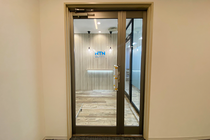 ガラスパーテーションと木目メラミンで仕上げたエントランス